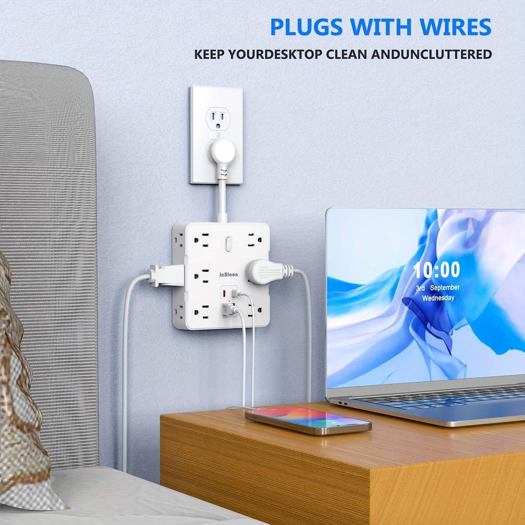 Bedroom scene with a power strip, plugs, and a laptop on a desk.