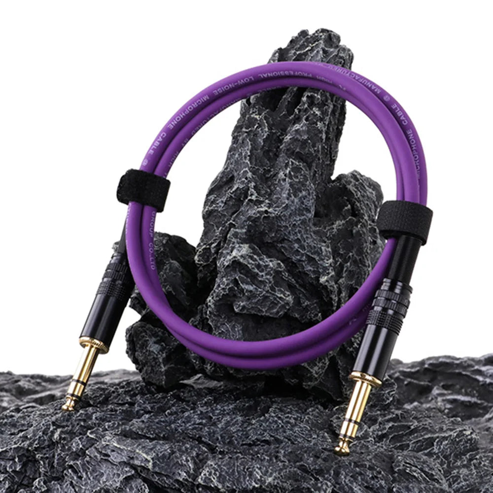 Purple audio cable coiled on a rock with a white background