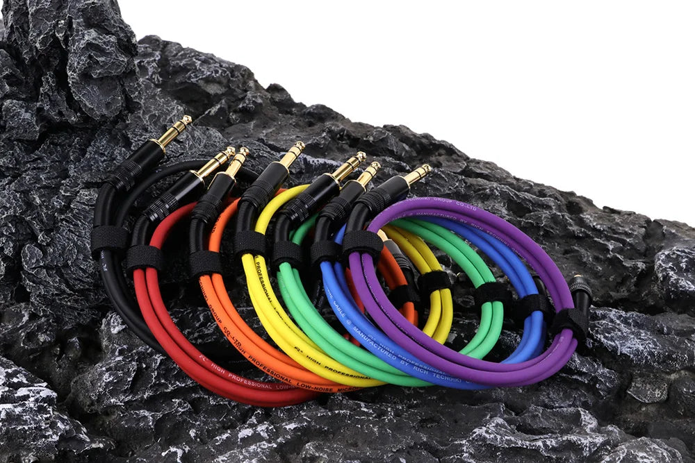 Set of colorful audio cables on a rocky surface