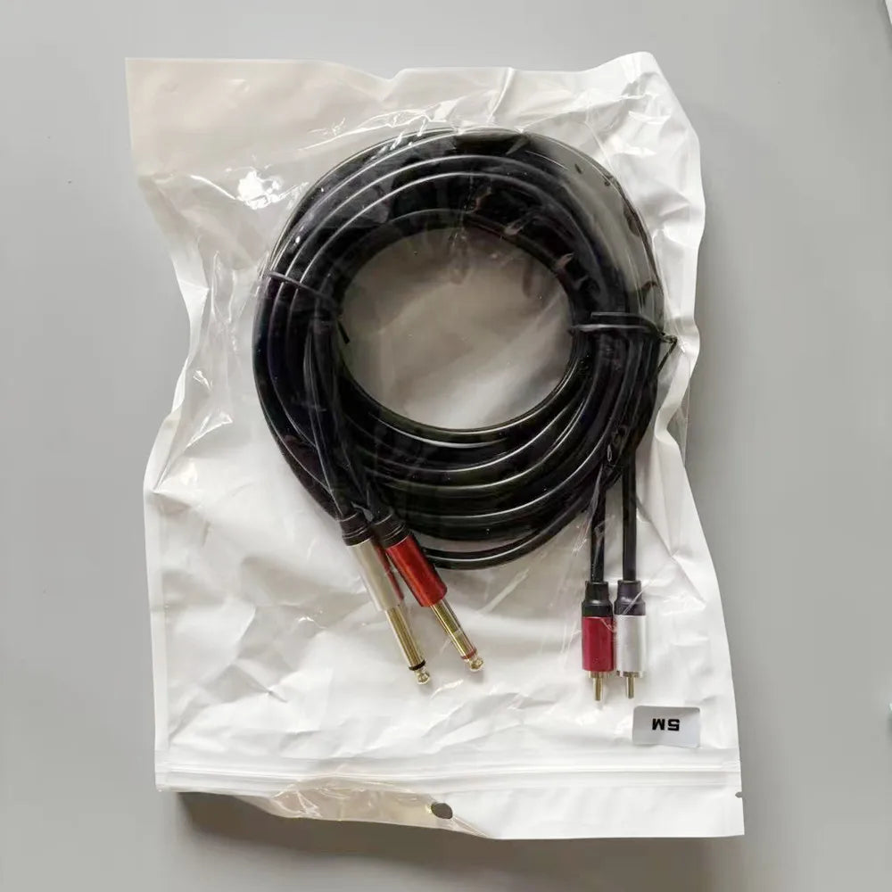 Set of audio cables in a clear plastic bag on a gray background