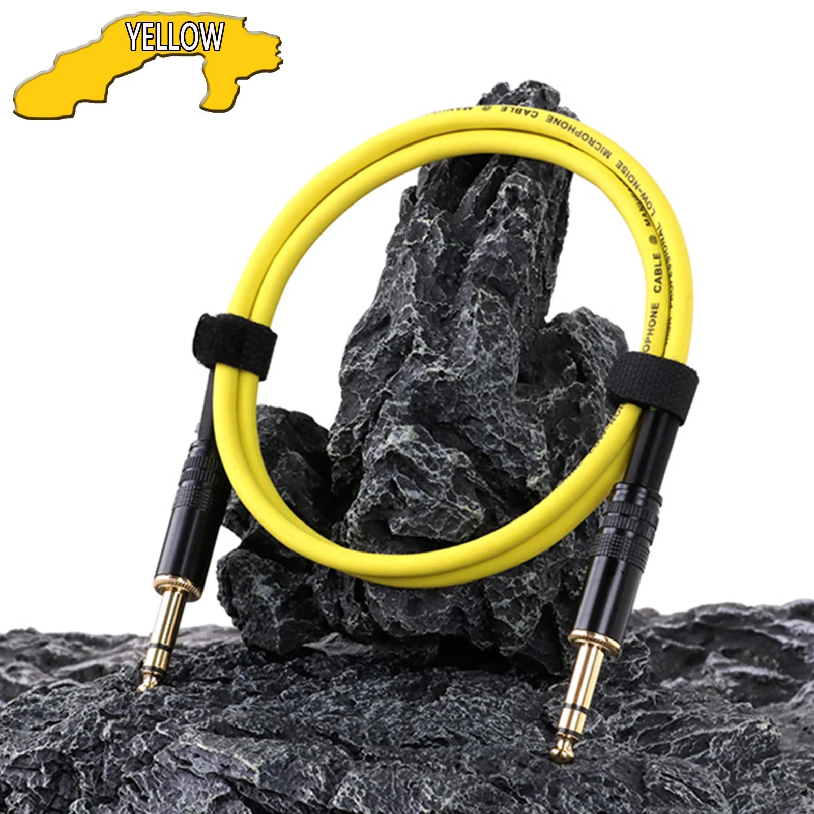 Yellow audio cable with black connectors on a rocky surface