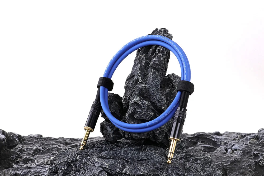 Blue audio cable coiled on a rock with white background