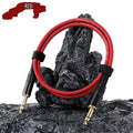 RED audio cable with black connectors on a rocky surface