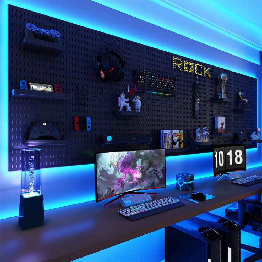 Gaming setup with a desk, monitor, keyboard, and various gaming accessories against a pegboard wall.